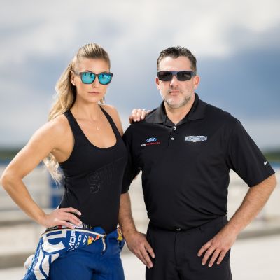 Both are wearing shades while putting their hands on their hip.